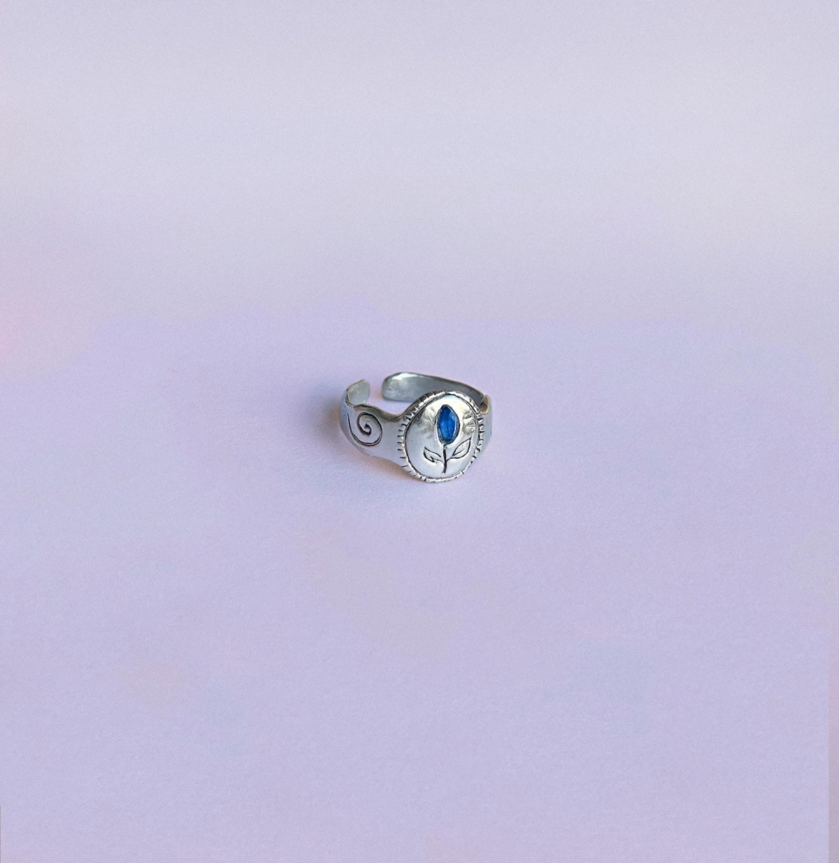 Chevalière RachaJewellery en argent, plateau ovale floral, saphir bleu et spirales latérales, anneau ajustable